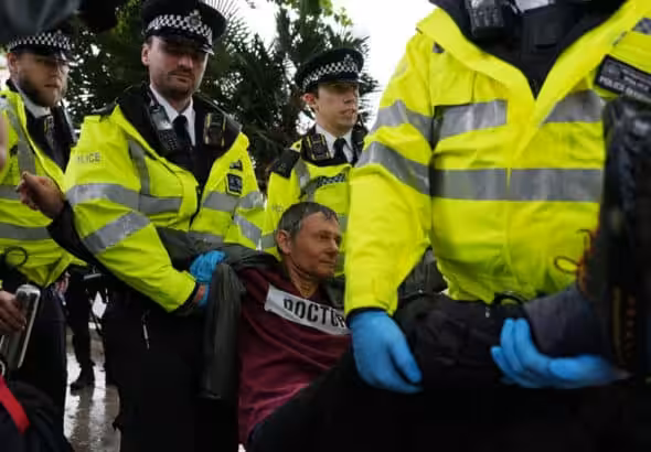 A protester is carried away by police officers at a rally in support of Palestine Action in Parliament Square, central London, on July 19, 2025. Photo: Carlos Jasso/AFP.