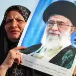 An Iranian woman holds a portrait of supreme leader Ayatollah Ali Khamenei. Photo: Atta Kenare/AFP.