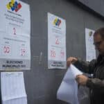 A man places the voting list at a polling station in Caracas this Sunday. Voting centers began opening their doors this Sunday in Venezuela. Photo: Boris Vergara/EFE.