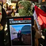 A protestor holds a placard during the demonstration. Hundreds of Palestine Action protestors congregated at HMP Brixton Prison to lobby for the release of all Political Prisoners on their annual New Yearâs Eve âNoise Demoâ. Photo: Lab Ky Mo/Sipa/AP Images