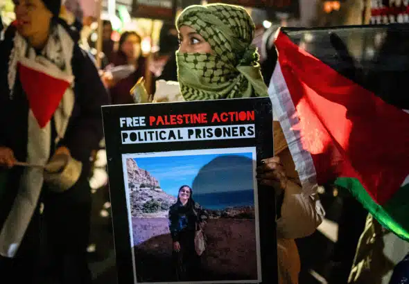 A protestor holds a placard during the demonstration. Hundreds of Palestine Action protestors congregated at HMP Brixton Prison to lobby for the release of all Political Prisoners on their annual New Year’s Eve “Noise Demo”. Photo: Lab Ky Mo/Sipa/AP Images