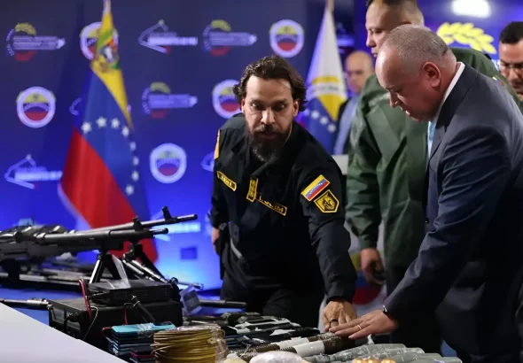 The image shows Venezuelan Interior Minister Diosdado Cabello inspecting war weapons and equipment seized from drug-trafficking groups linked to Venezuelan far-right opposition. Photo: Telesur.