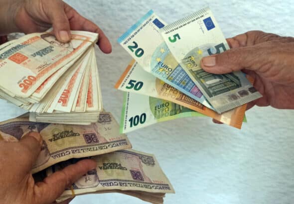 People hold Cuban peso, US dollar, and euro notes. Photo: EFE/Ernesto Mastrascusa.