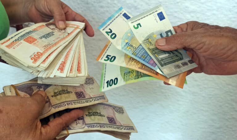 People hold Cuban peso, US dollar, and euro notes. Photo: EFE/Ernesto Mastrascusa.