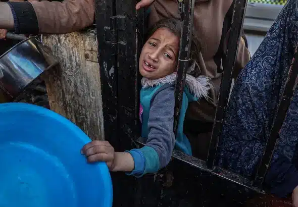 A child waits for food in line at a private food distribution center in Rafah, Gaza Strip, March 2025. Photo: Laoy Ayyoub.