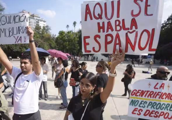 Anti-gentrification protestors in Mexico City hold signs demanding urgent real estate regulation, July 4, 2025. Photo: Fernando Llano/AP.