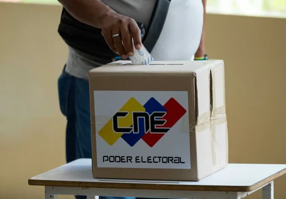 Person casting the electronic receipt of their vote in a ballot box. Photo: Venezuela News.