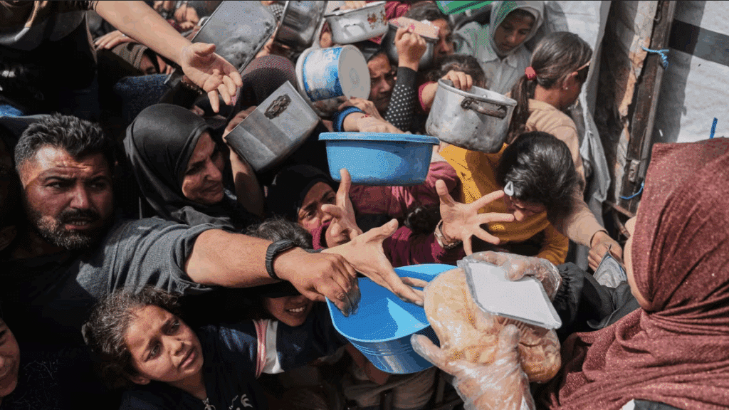 Palestinians struggle to receive food at a distribution center in Beit Lahiya in the northern Gaza Strip, April 7. Photo: Jehad Alshrafi/AP.