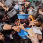 Palestinians struggle to receive food at a distribution center in Beit Lahiya in the northern Gaza Strip, April 7. Photo: Jehad Alshrafi/AP.