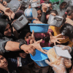 Palestinians struggle to receive food at a distribution center in Beit Lahiya in the northern Gaza Strip, April 7. Photo: Jehad Alshrafi/AP.