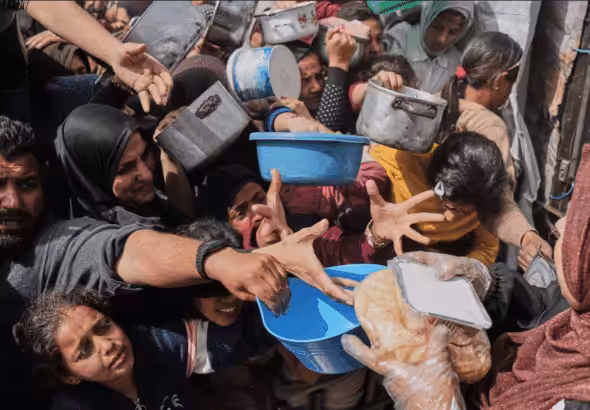 Palestinians struggle to receive food at a distribution center in Beit Lahiya in the northern Gaza Strip, April 7. Photo: Jehad Alshrafi/AP.