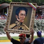 A man holds a portrait of Simón Bolívar at Venezuela's independence day celebrations. Photo: Getty Images.