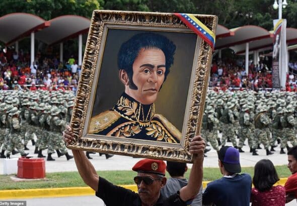 A man holds a portrait of Simón Bolívar at Venezuela's independence day celebrations. Photo: Getty Images.