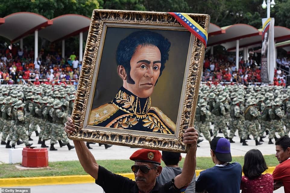 A man holds a portrait of Simón Bolívar at Venezuela's independence day celebrations. Photo: Getty Images.