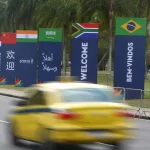 Taxi passing by street posters with the flags of BRICS countries in Rio de Janeiro. Photo: Rio City Hall.
