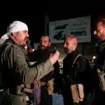 A Druze gunman, left, speaks with Syrian security forces who reached a deal with locals to deploy around the southern Damascus suburb of Jaramana that has witnessed fighting earlier this week in Damascus, Syria, on May 2, 2025. Photo: AP.