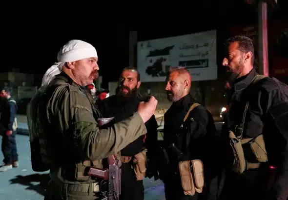 A Druze gunman, left, speaks with Syrian security forces who reached a deal with locals to deploy around the southern Damascus suburb of Jaramana that has witnessed fighting earlier this week in Damascus, Syria, on May 2, 2025. Photo: AP.
