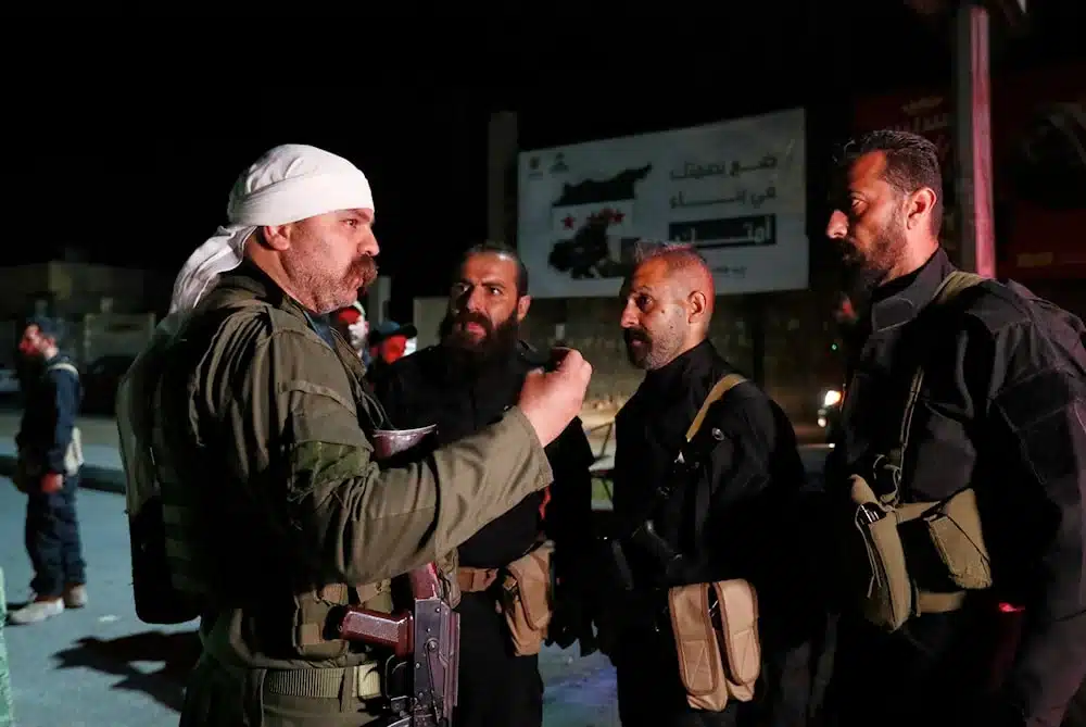 A Druze gunman, left, speaks with Syrian security forces who reached a deal with locals to deploy around the southern Damascus suburb of Jaramana that has witnessed fighting earlier this week in Damascus, Syria, on May 2, 2025. Photo: AP.