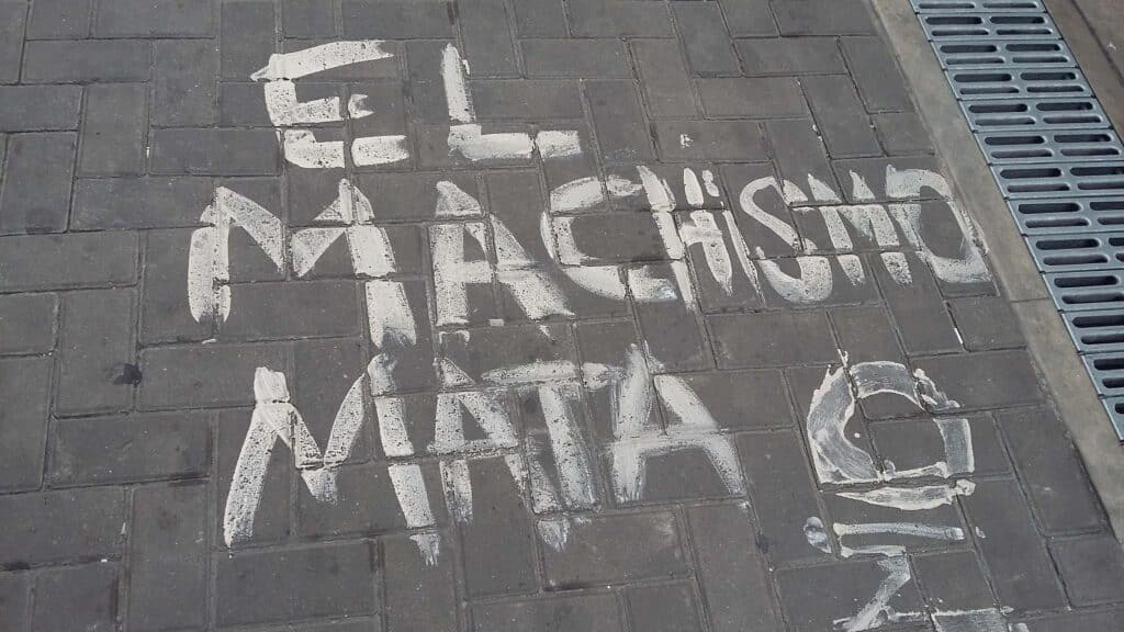 Painting on a sidewalk reading “Machismo Kills.” File photo.