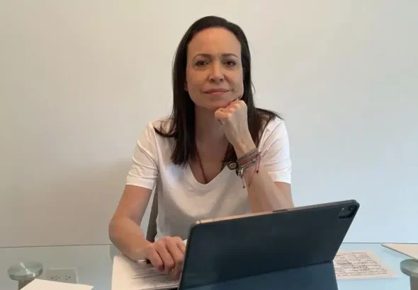 Far-right Venezuelan politician María Corina Machado seating behind a laptop. Photo: ABC.