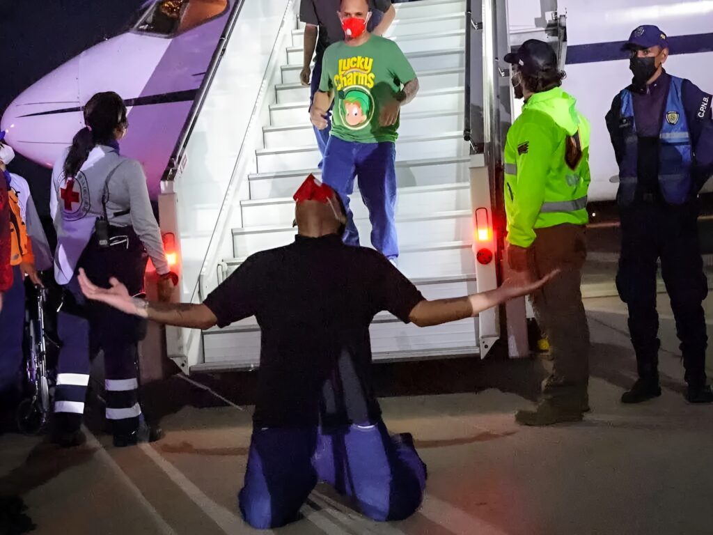 Venezuelan migrant rescued from El Salvador's CECOT torture center kneeling on Venezuelan soil after deboarding the plane that brought him back home, July 18, 2025. Photo: Con el Mazo Dando.