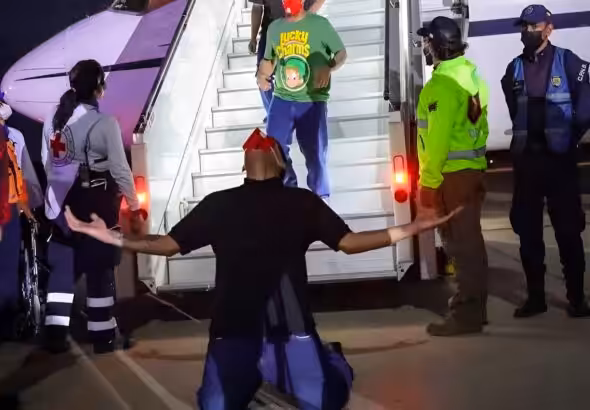 Venezuelan migrant rescued from El Salvador's CECOT torture center kneeling on Venezuelan soil after deboarding the plane that brought him back home, July 18, 2025. Photo: Con el Mazo Dando.