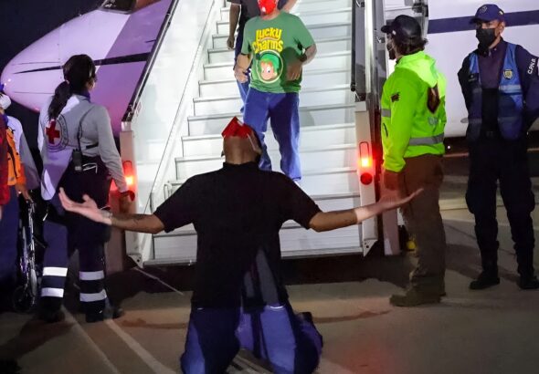 Venezuelan migrant rescued from El Salvador's CECOT torture center kneeling on Venezuelan soil after deboarding the plane that brought him back home, July 18, 2025. Photo: Con el Mazo Dando.