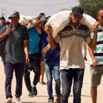 Palestinians carry humanitarian aid they received through the Rafah corridor in the southern Gaza Strip on July 28, 2025. Photo: AFP.