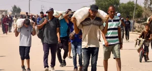 Palestinians carry humanitarian aid they received through the Rafah corridor in the southern Gaza Strip on July 28, 2025. Photo: AFP.