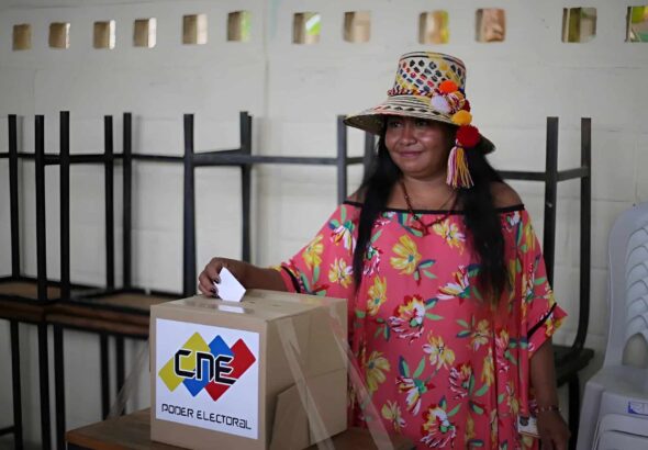 Indigenous woman casting the electronic receipt of her vote during Indigenous elections for municipal councilors in Venezuela. Photo: Telesur.