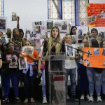 Family members hold signs calling for the return of their children. Photo: María Isabel Batista.