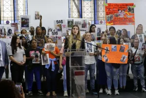 Family members hold signs calling for the return of their children. Photo: María Isabel Batista.