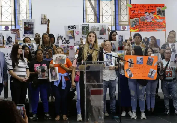 Family members hold signs calling for the return of their children. Photo: María Isabel Batista.