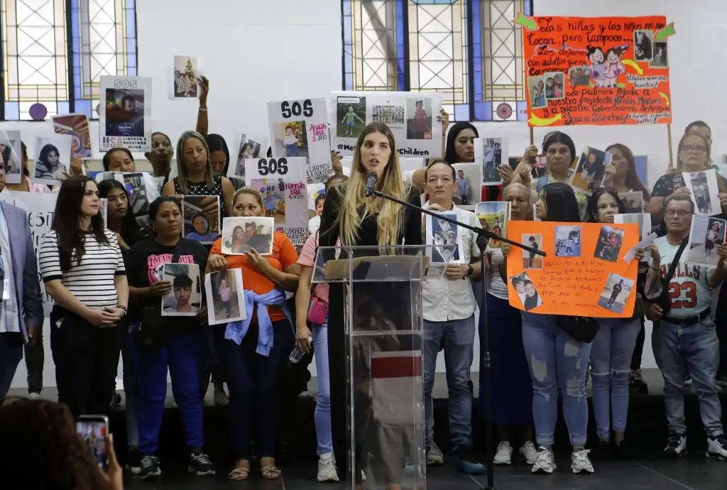 Family members hold signs calling for the return of their children. Photo: MarĂa Isabel Batista.