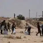 Palestinians collect airdropped aid packages in central Gaza Strip on August 9, 2025. Photo: AP.