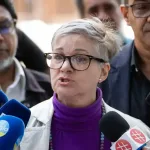 Venezuelan lawyer Maria Alejandra Diaz issuing a statement to the press in 2024; she is escorted by Venezuelan Communist Party members, including the secretary general, Oscar Figuera. Photo: Ronald Peña R./EFE/file photo.