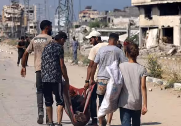 Palestinians carry the body of a person who was killed while seeking food at a distribution point run by the Gaza Humanitarian Foundation (GHF) on Salah al-Din Street in Nuseirat. Photo: AFP.