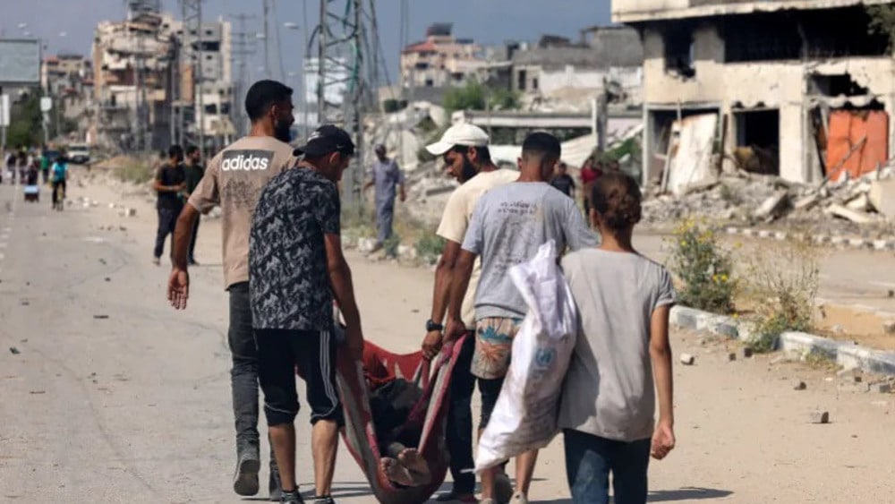 Palestinians carry the body of a person who was killed while seeking food at a distribution point run by the Gaza Humanitarian Foundation (GHF) on Salah al-Din Street in Nuseirat. Photo: AFP.