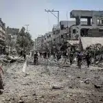 People walking on what remains of a Gaza street after nearly two years of "Israel's" genocidal military campaign in August 2025. Photo: Hames Alrefi/Anadolu via Getty Images.
