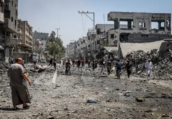 People walking on what remains of a Gaza street after nearly two years of "Israel's" genocidal military campaign in August 2025. Photo: Hames Alrefi/Anadolu via Getty Images.