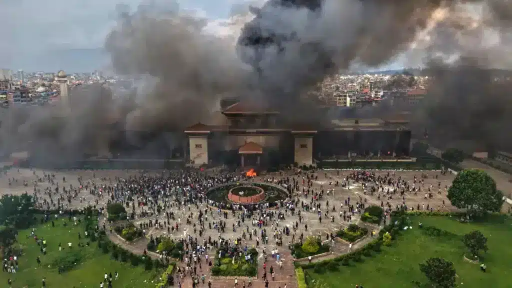 Protesters celebrate at the Singha Durbar, the seat of Nepal's government various ministries and offices after it was set on fire during a protest against special media ban and corruption in Kathmandu, Nepal, Tuesday, Sept. 9, 2025. Photo: Prakash Tiimalsina/AP.