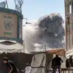 People run as smoke rises over a building in Gaza City, September 14, 2025. Photo: Omar Al Qattaa/AFP.