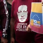 A person wears a t-shirt with the silhouette of President Hugo Chávez while another holds a paper sheet that reads "yo me enlisto" ("I am going to enlist"). Photo: Juan Carlos Hernández/contactophoto.