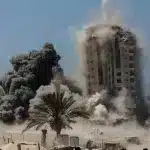 Zionist bombardment levels Mushataha Tower, a residential building in Gaza City. Photo: AFP.