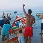 Fishermen assist a fellow vessel in Punta Araya, Sucre state, Venezuela. Photo: Rodrigo Abd/AP/File photo.