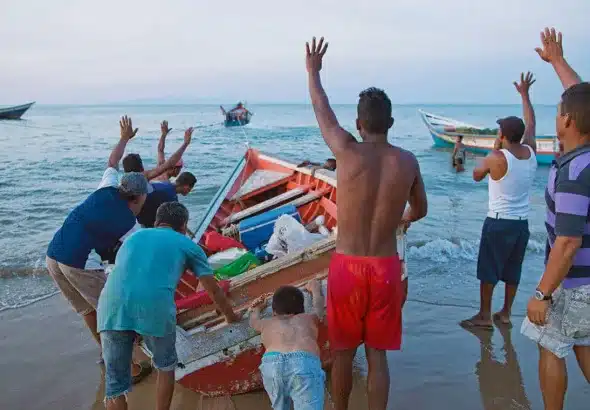 Fishermen assist a fellow vessel in Punta Araya, Sucre state, Venezuela. Photo: Rodrigo Abd/AP/File photo.