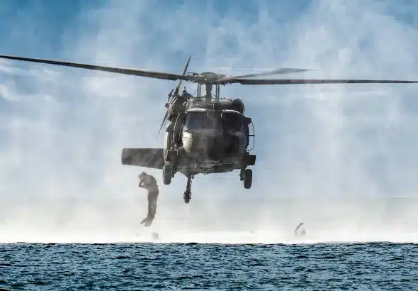 A US Sikorsky UH-60 Black Hawk helicopter conducting maritime operations with a special tactics airman descending into the water. Photo: US Air National Guard/file photo.