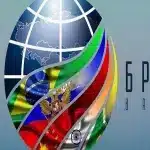 An image composition showing a logo of the globe, with BRICS member country flags superimposed on it, and the acronyms SCO and BRICS to each side. Photo: File photo.