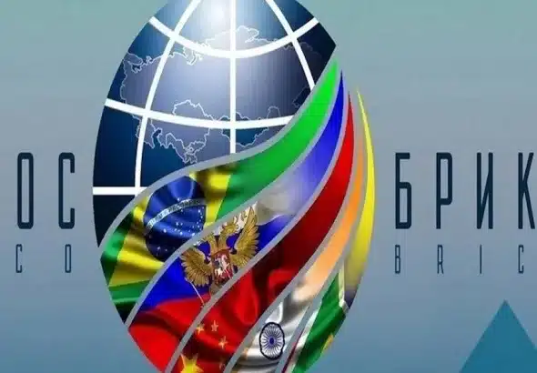 An image composition showing a logo of the globe, with BRICS member country flags superimposed on it, and the acronyms SCO and BRICS to each side. Photo: File photo.