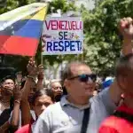 Venezuelans hold signs and flags in a demonstration. Photo: EFE.